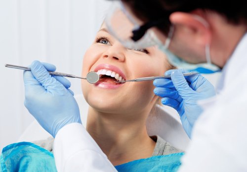 Orthodontist examining a patient’s teeth with dental equipment